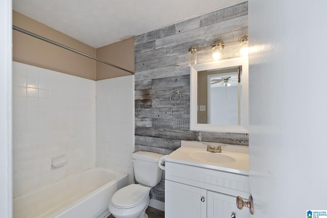 full bathroom with wooden walls, bathtub / shower combination, vanity, toilet, and a textured ceiling