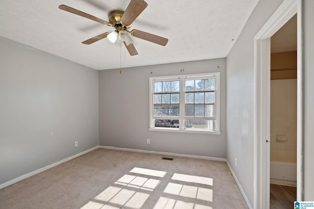 interior space featuring ceiling fan, light colored carpet, and a textured ceiling