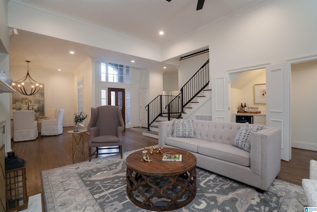 living room featuring crown molding, dark wood-type flooring, and an inviting chandelier