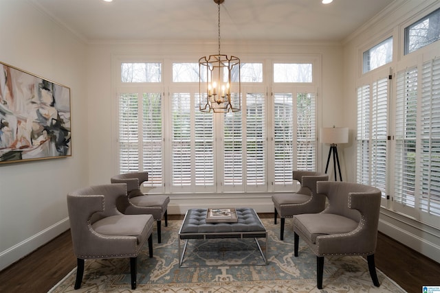 sitting room with hardwood / wood-style floors, crown molding, and a chandelier