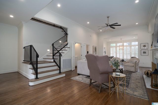 living room featuring dark wood-type flooring, ceiling fan, and crown molding