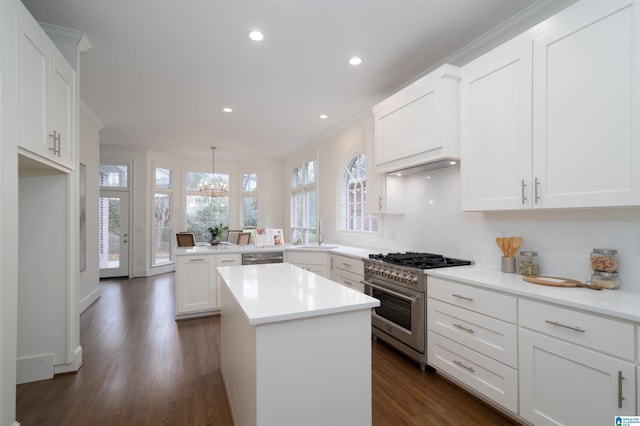 kitchen featuring white cabinetry, stainless steel appliances, decorative light fixtures, and a kitchen island