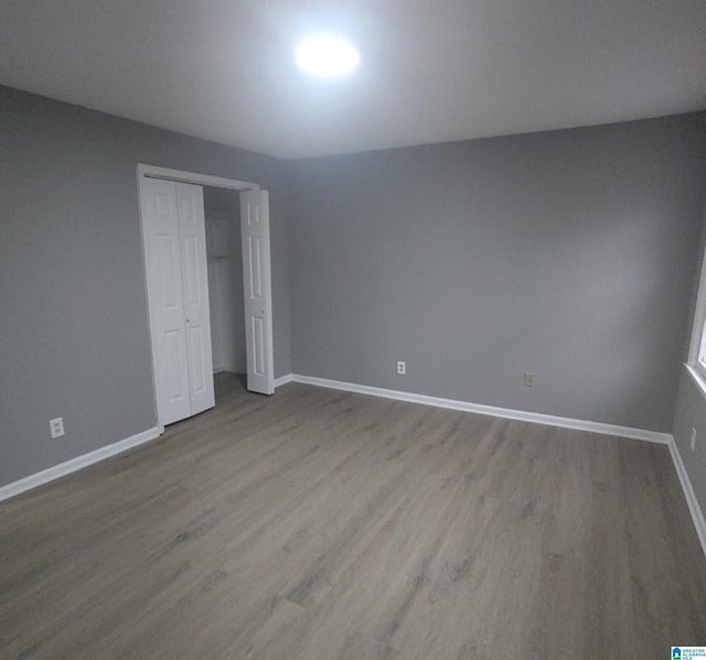 unfurnished bedroom featuring light hardwood / wood-style floors and a closet