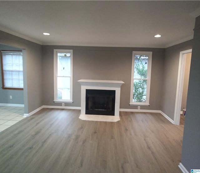 unfurnished living room with crown molding and light wood-type flooring