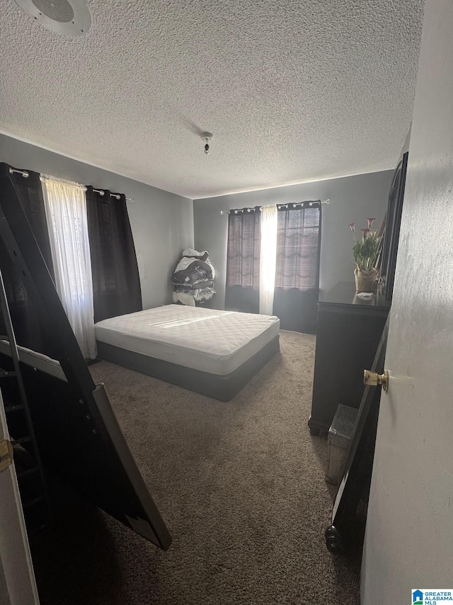 bedroom with carpet floors and a textured ceiling