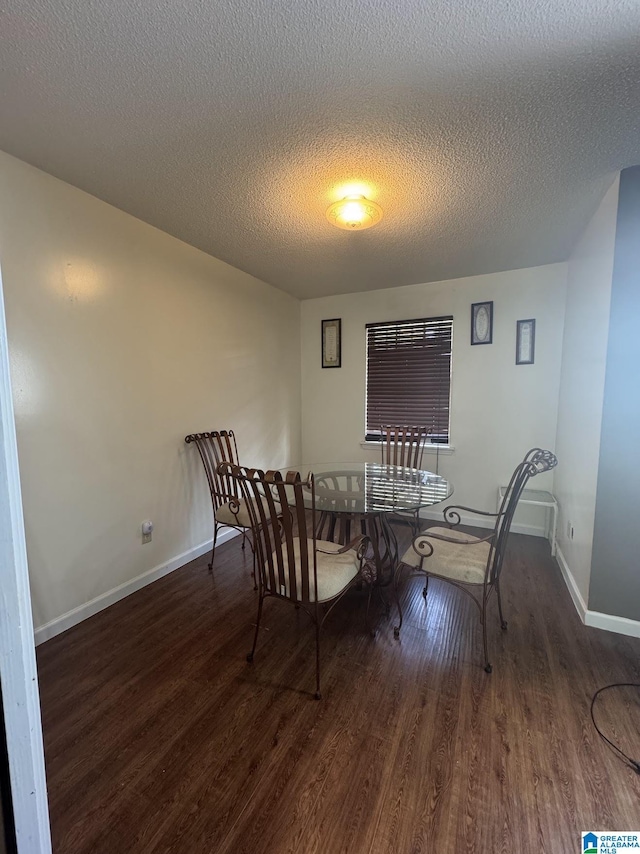 dining room with dark hardwood / wood-style floors and a textured ceiling