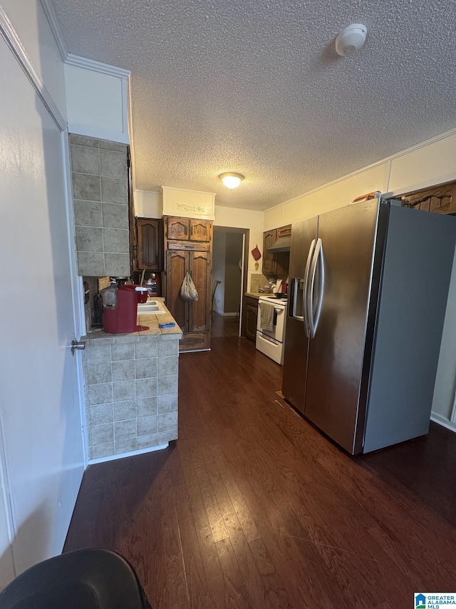 kitchen featuring sink, white range with electric cooktop, dark hardwood / wood-style floors, stainless steel refrigerator with ice dispenser, and a textured ceiling