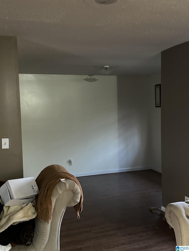 sitting room featuring dark hardwood / wood-style floors and a textured ceiling