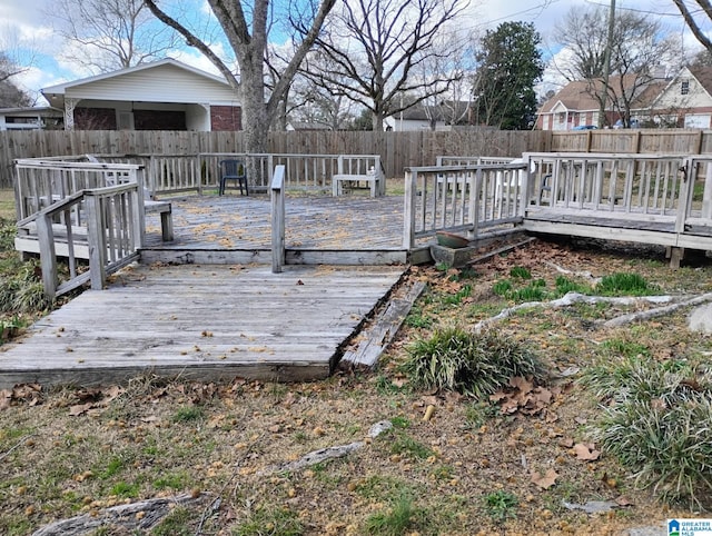 wooden terrace with a fenced backyard