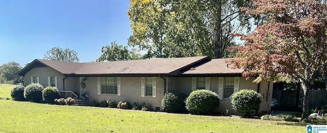 view of front of property featuring brick siding and a front lawn