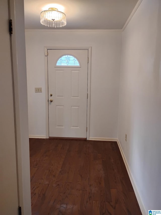 doorway featuring ornamental molding, dark wood-type flooring, and baseboards