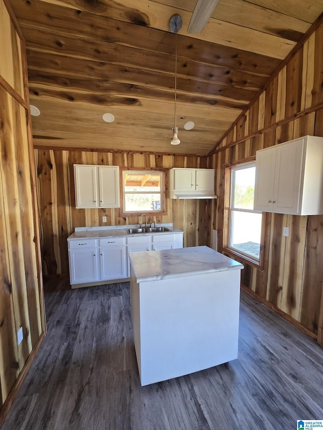 kitchen with sink, wood ceiling, hanging light fixtures, a kitchen island, and white cabinets