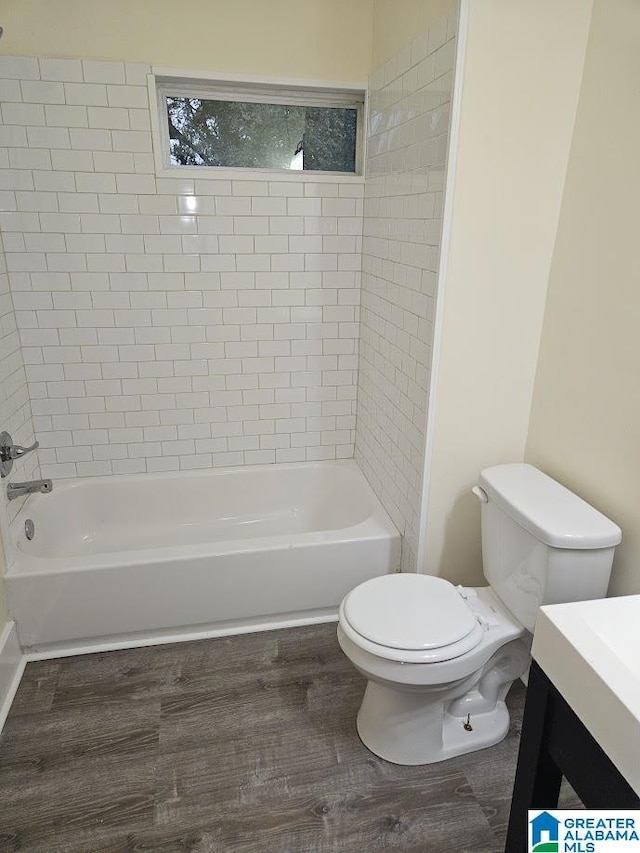 full bathroom featuring wood-type flooring, toilet, vanity, and tiled shower / bath