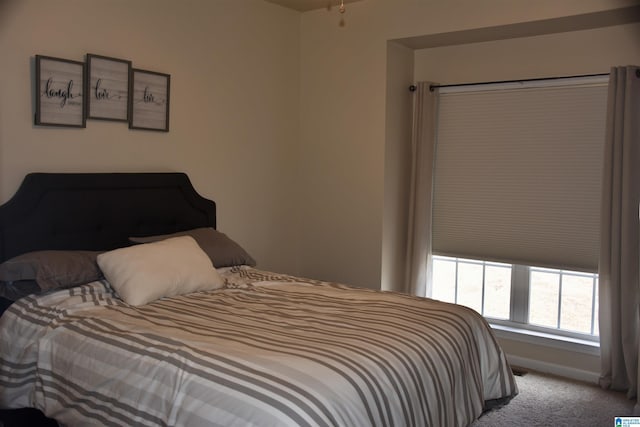 bedroom featuring light carpet and baseboards