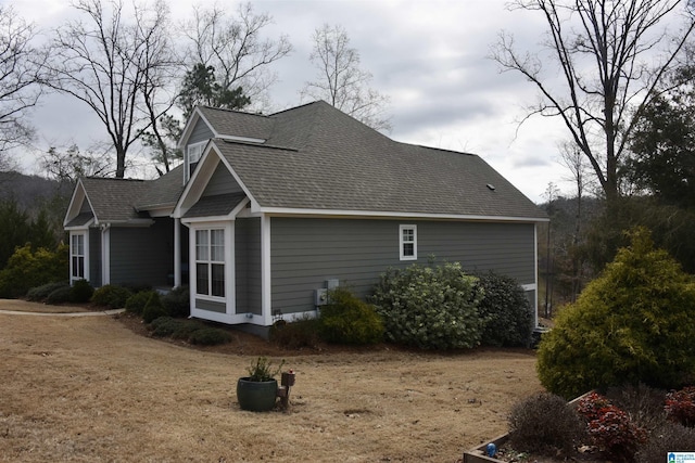 view of side of property with a shingled roof