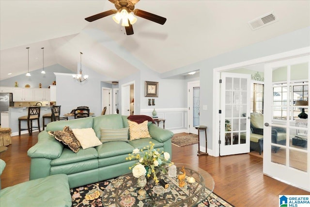 living room featuring french doors, dark hardwood / wood-style floors, ceiling fan with notable chandelier, and vaulted ceiling