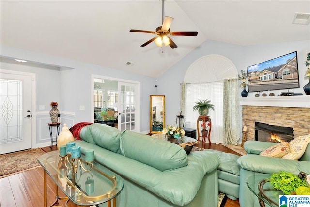 living room featuring hardwood / wood-style flooring, lofted ceiling, plenty of natural light, and a fireplace