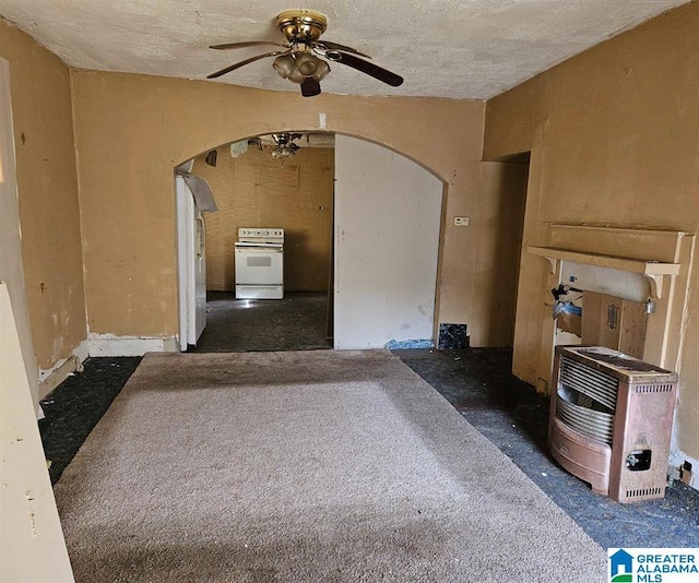 unfurnished living room featuring heating unit, ceiling fan, and a textured ceiling