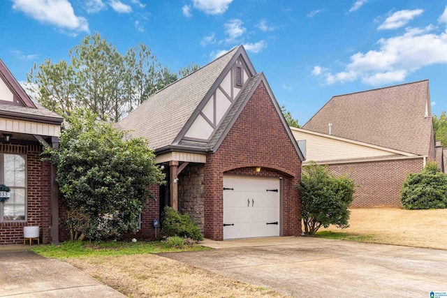 english style home featuring a garage