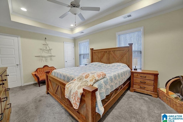 carpeted bedroom with a raised ceiling, crown molding, and ceiling fan