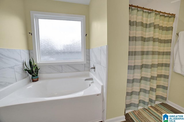 bathroom featuring independent shower and bath