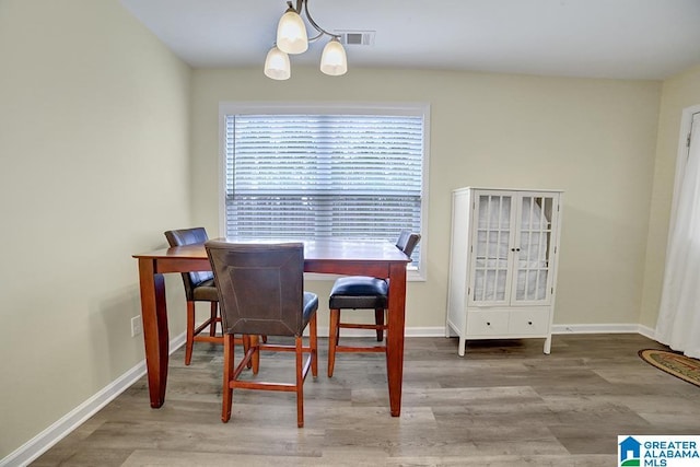 dining room with hardwood / wood-style floors and a notable chandelier