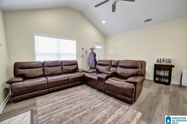 living room featuring light hardwood / wood-style flooring, high vaulted ceiling, and ceiling fan