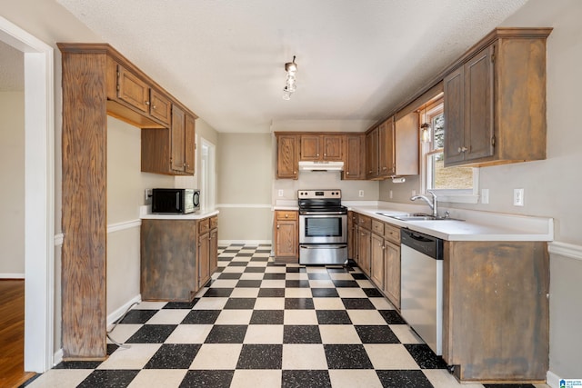 kitchen featuring appliances with stainless steel finishes, sink, and a textured ceiling