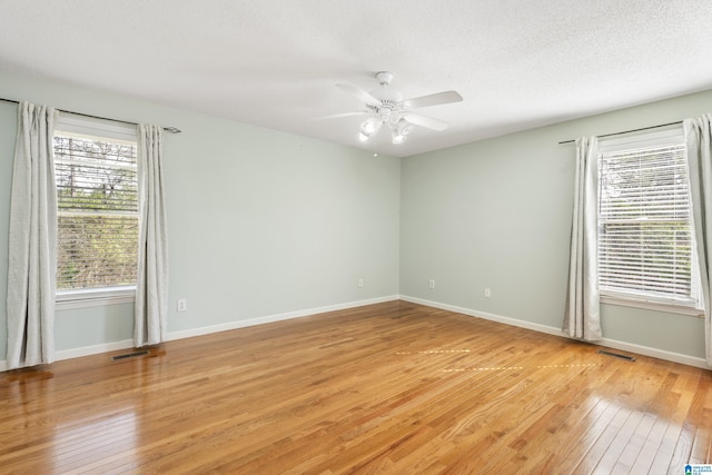 empty room featuring ceiling fan, light hardwood / wood-style floors, and a textured ceiling