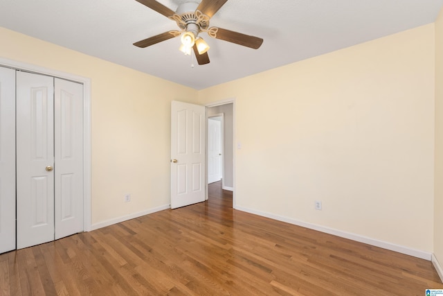 unfurnished bedroom with wood-type flooring, a closet, and ceiling fan