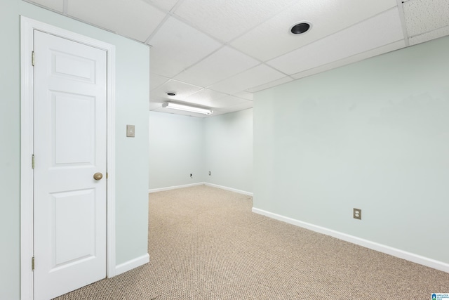 basement featuring a paneled ceiling and carpet floors