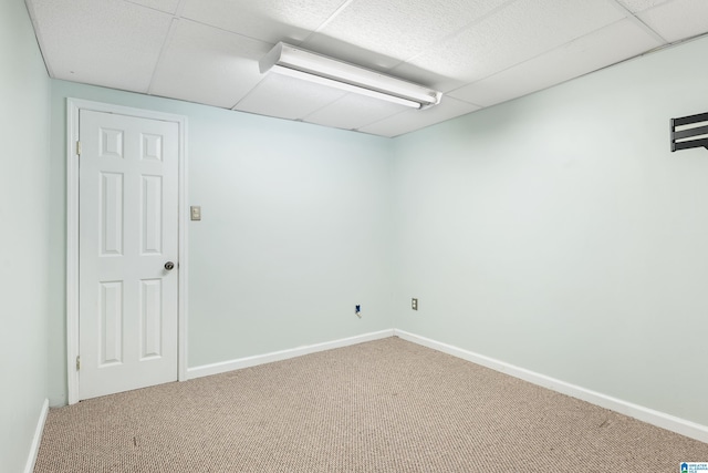 unfurnished room featuring carpet and a drop ceiling