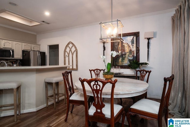 dining area with dark hardwood / wood-style flooring and crown molding