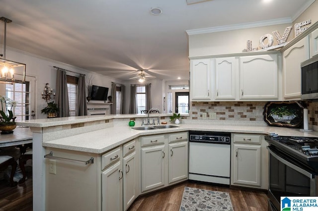 kitchen featuring decorative light fixtures, sink, ornamental molding, kitchen peninsula, and stainless steel appliances