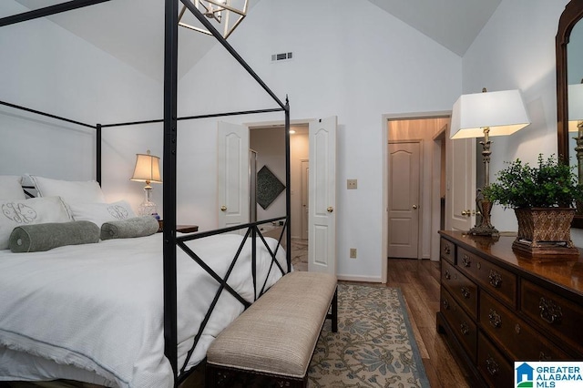 bedroom with dark hardwood / wood-style floors and high vaulted ceiling