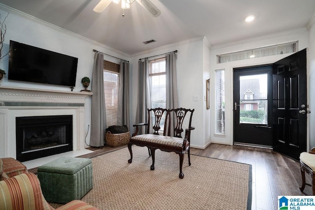 entryway with ceiling fan, ornamental molding, and wood-type flooring