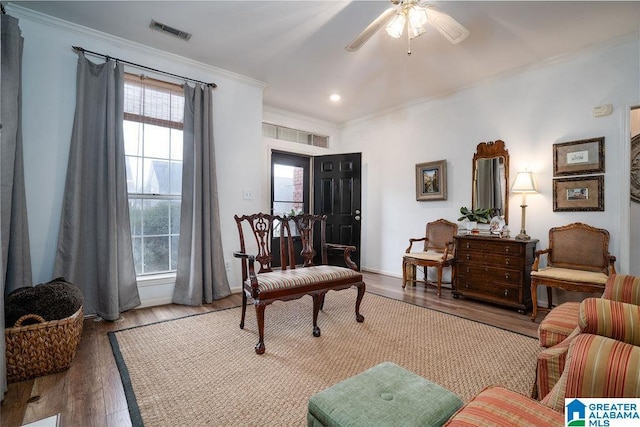 living area with ornamental molding, ceiling fan, and light hardwood / wood-style floors