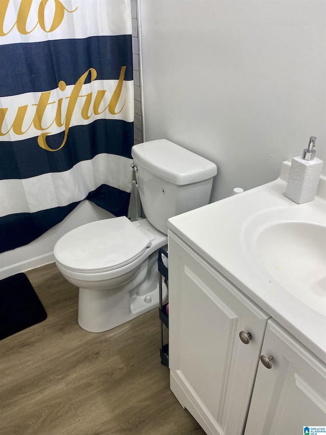 bathroom featuring vanity, hardwood / wood-style floors, walk in shower, and toilet