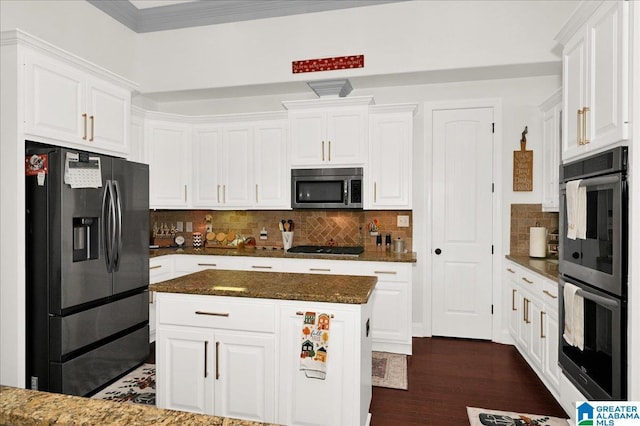 kitchen featuring decorative backsplash, stainless steel appliances, dark stone counters, and white cabinets