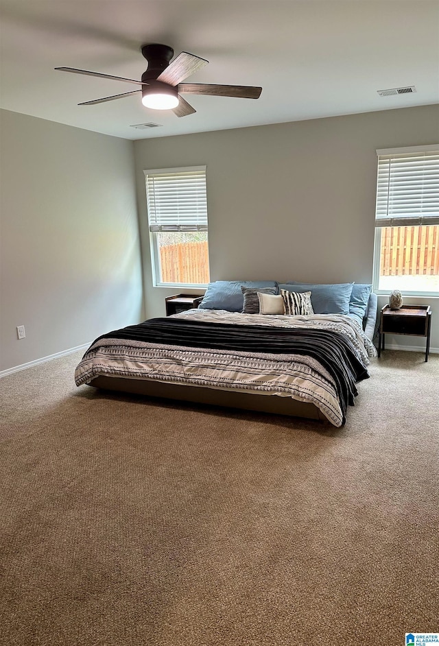 bedroom featuring carpet floors, multiple windows, and visible vents