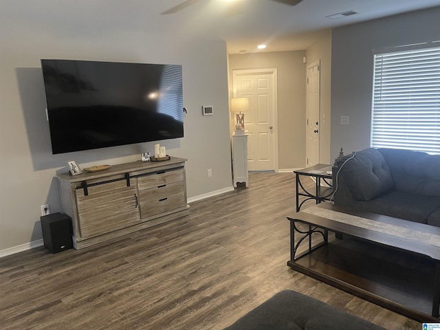 living room with dark wood-type flooring, visible vents, and baseboards