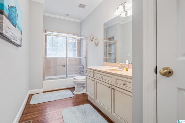 full bathroom with hardwood / wood-style floors, enclosed tub / shower combo, ornamental molding, vanity, and toilet