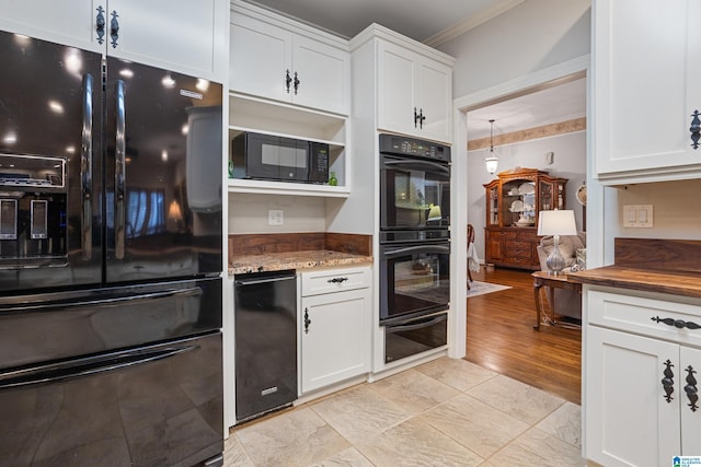 kitchen featuring white cabinetry, ornamental molding, dark stone counters, and black appliances