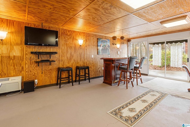 interior space featuring carpet floors, bar area, wooden walls, and wood ceiling