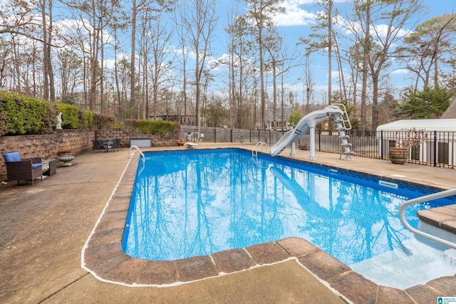 view of swimming pool with a patio area and a water slide