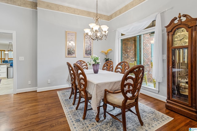 dining area featuring dark hardwood / wood-style flooring, a notable chandelier, and crown molding