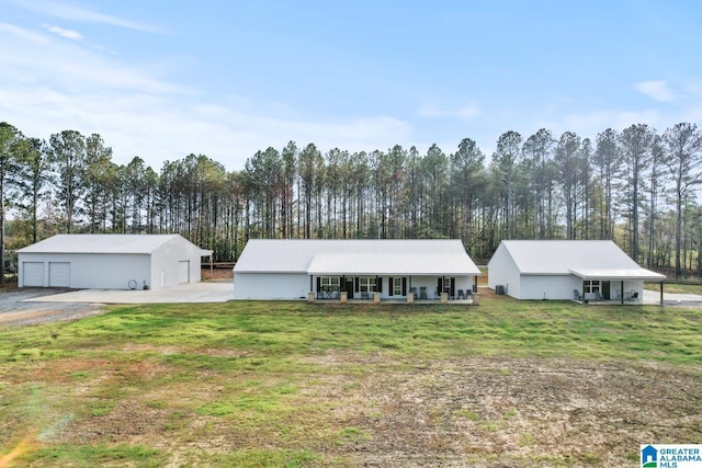 single story home with an outbuilding, a garage, a front yard, and a porch