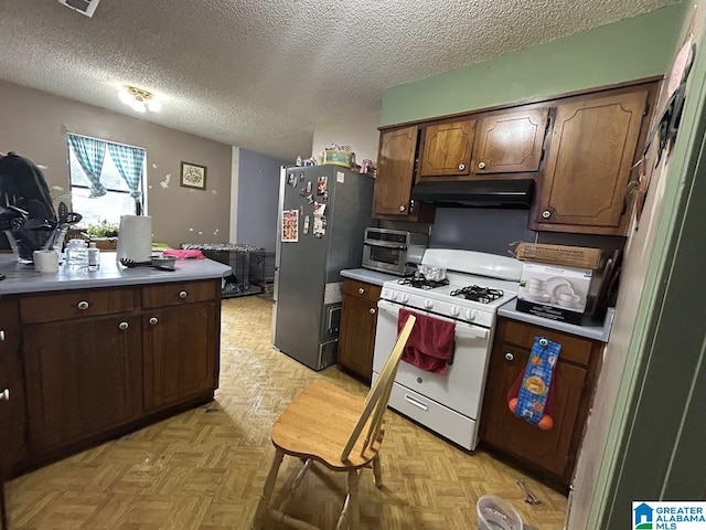 kitchen featuring a textured ceiling, stainless steel fridge, light parquet floors, and white range with gas stovetop