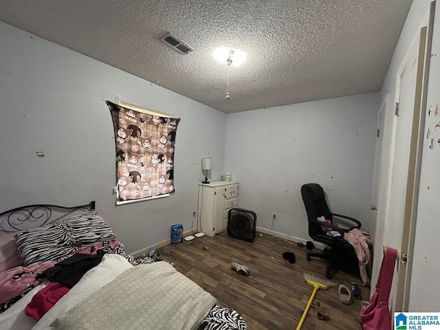 bedroom with dark wood-type flooring and a textured ceiling