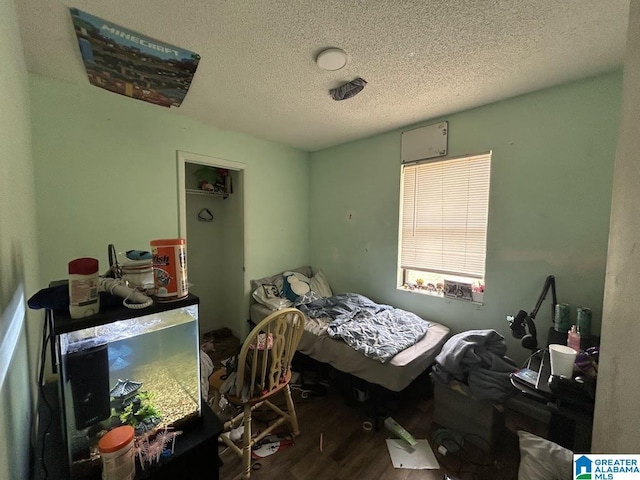 bedroom featuring hardwood / wood-style floors and a textured ceiling